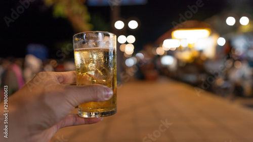 A beer mug with a handle and a beautiful bokeh background at night.