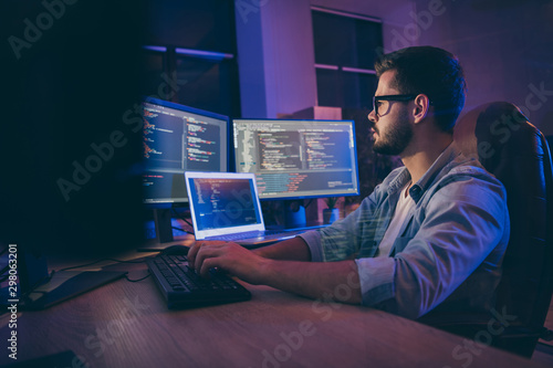 Profile side view portrait of his he nice attractive skilled smart focused concentrated guy consultant writing script creating new digital desktop app in dark room workplace station indoors photo