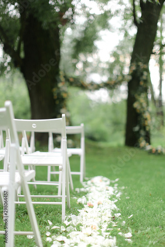 White chairs and arh for wedding in park. photo