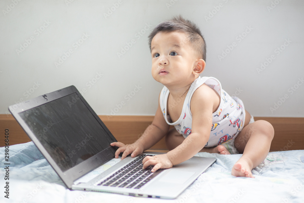 Cute asian baby boy playing laptop computer Cute asian baby boy playing laptop computer