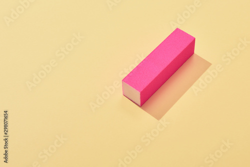 Soft pink nail buffer block on yellow background