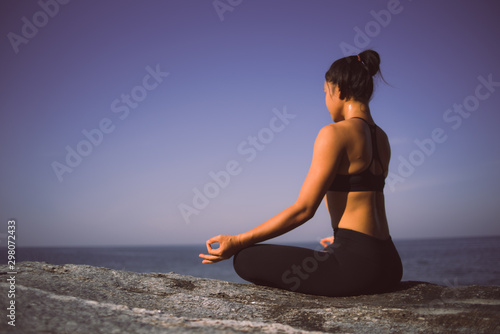 Asian girl practice Yoga on the beach Sunrise morning day