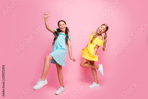 Full body profile photo of two people funny small school ladies models rejoicing summer holidays start wear bright blue yellow dresses isolated pink color background