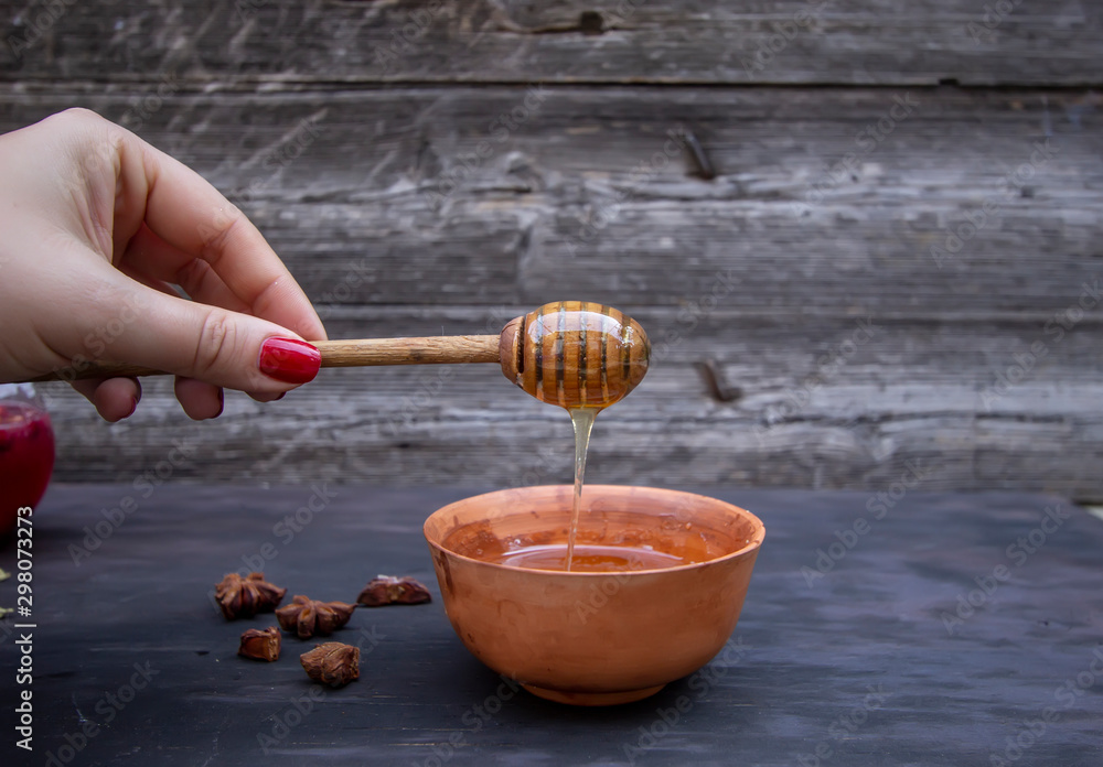 Fototapeta premium juniper honey spoon in the hands of a girl