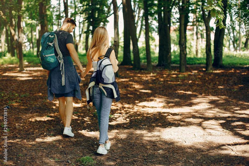 Tourists in a summer forest. Couple with a map. Tourists in a summer forest. Couple with a map.