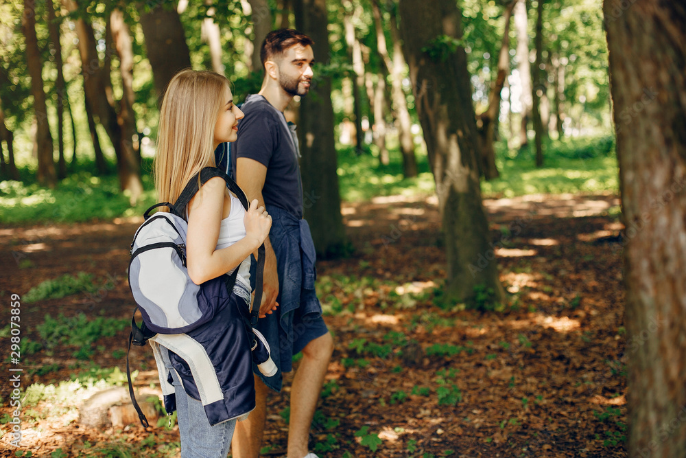 Tourists in a summer forest. Couple with a map. Tourists in a summer forest. Couple with a map.