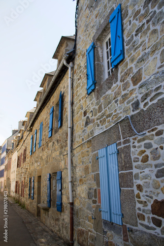 Vielle rue de maisons en pierre aux volets bleu en Bretagne