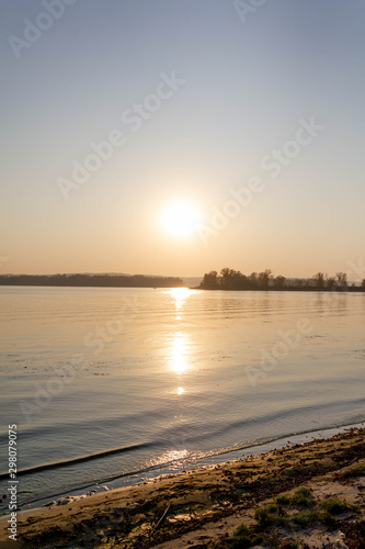 Sunset on the lake  river on the horizon trees