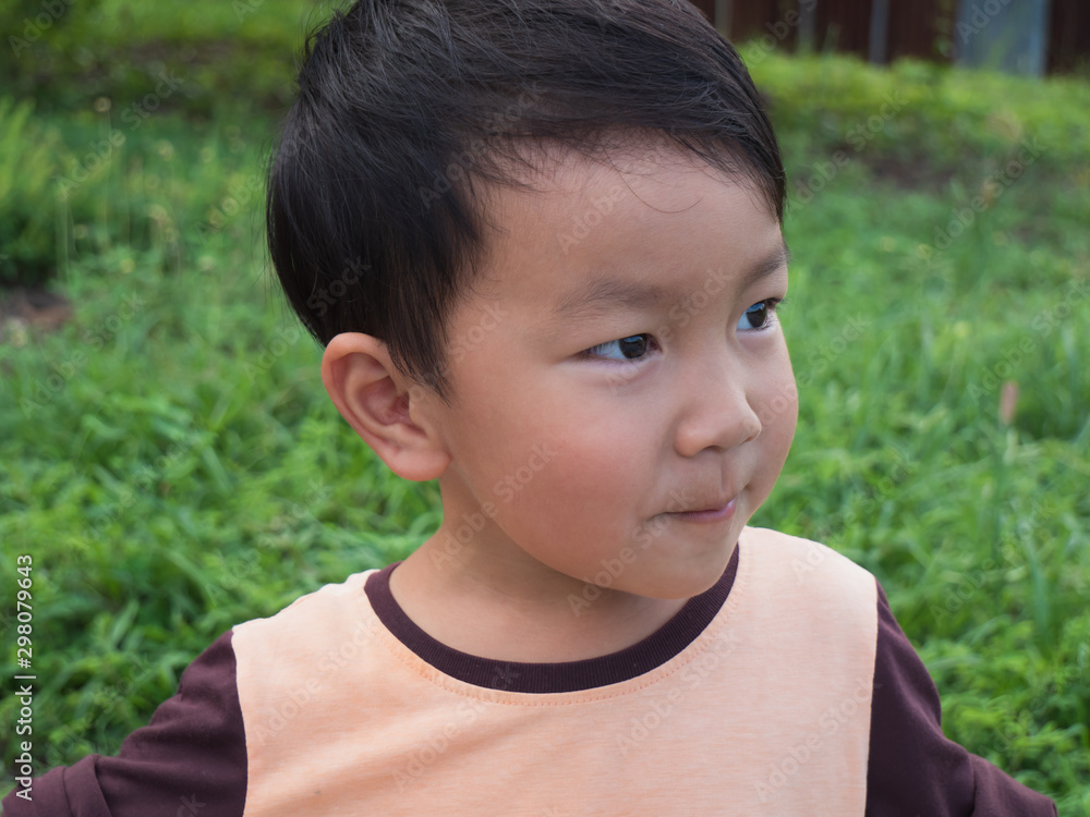 Asian child boy with happy close up funny face outdoor with natural background. Family relax and freedom time in summer holiday. Young kid smile while playing outdoor. Asian child boy with happy close up funny face outdoor with natural background. Family relax and freedom time in summer holiday. Young kid smile while playing outdoor.