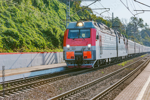 Passenger train from Adler moves by Black sea coast.