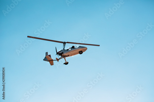 White small double gyroplane autogyro without a cabin against the blue sky. Air tours for tourists.