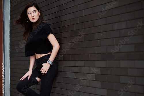 A beautiful Asian woman wearing street clothes in black color in standing pose.