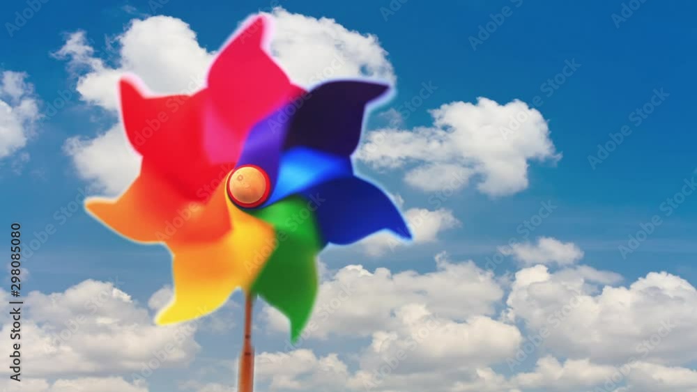 Colorful pinwheel toy against blue sky and clouds Colorful pinwheel toy against blue sky and clouds