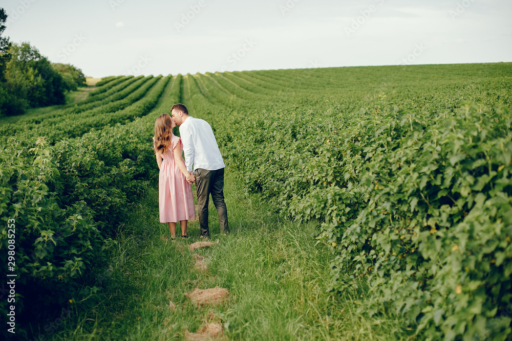 Couple in a field. Girl in a pink dress. Man in a white shirt