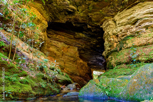 Cave interior with small river and lake surrounded by vegetation of Brazilian jungle