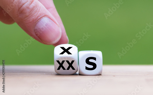 Gaining weight concept. Hand turns a dice and changes the expression "XX-S" to "X-S".