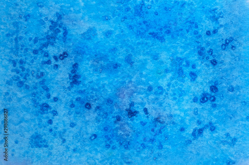 Blue watercolor paint background. Blue watercolor paint with pieces of salt top view.