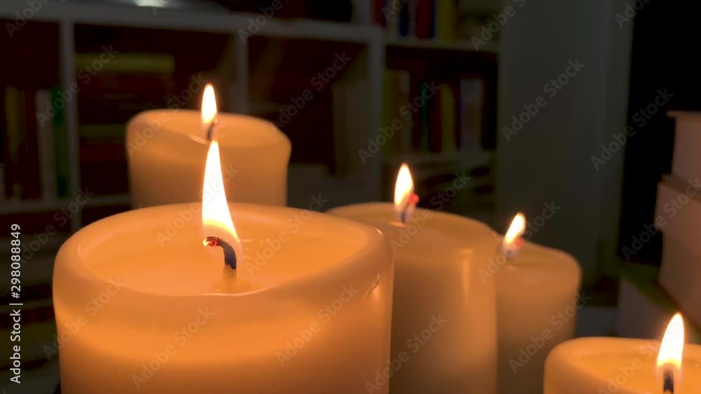 A few candles lit next to each other, the flame swings in slow motion A few candles lit next to each other, the flame swings in slow motion