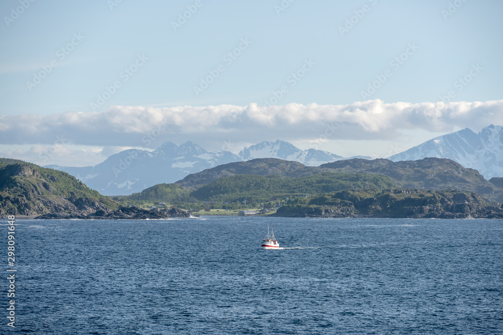 traditional small fish boat sailing near the northern coast of Andenes island, Norway