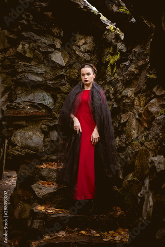 woman witch in red dress in a medieval castle.The medieval queen.  Evil witch