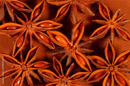 Christmas spice - Star anise on brown background, dry brown Anise star seeds, aromatic Asian spices ingredient in cooking, star anise background