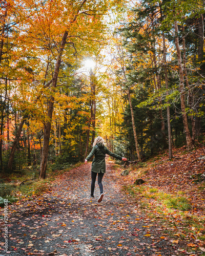 The girl is enjoying the view on colorfull trees during the fall in Nova scotia Canada