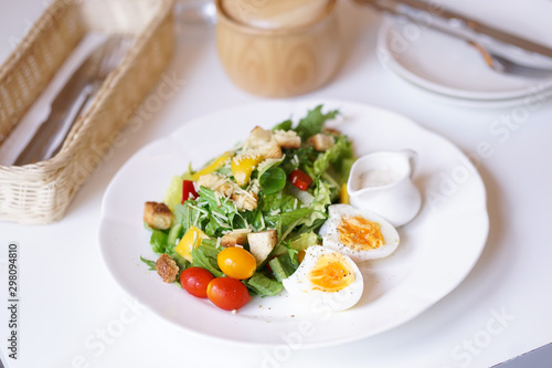 Cesar salad. A closed up of cesar salad with soft focus on the boiled egg. Window light.