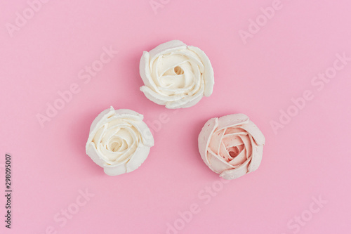 Flowers from marshmallow, sweet food background with copy space. Greeting card pastel colored. Top view and flat lay.