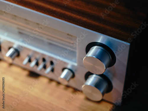 From above closeup of front of massive metallic retro turntable with built-in radio having radio dial with frequencies and set of controls photo