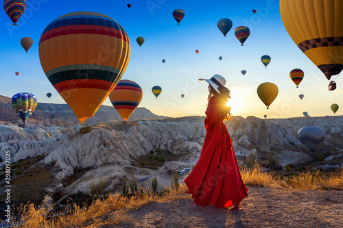 Beautiful girl standing and looking to hot air balloons in Cappadocia, Turkey. photo