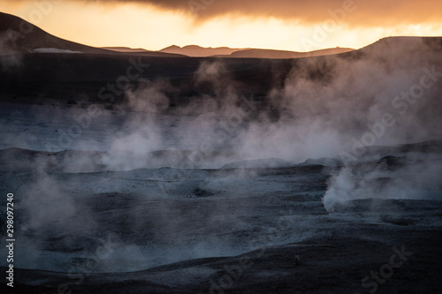Geyser and volcanic lands at sunrise. Geothermal industry.