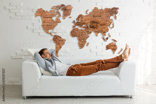 Contemporary board room man on sofa with wooden world map on wall