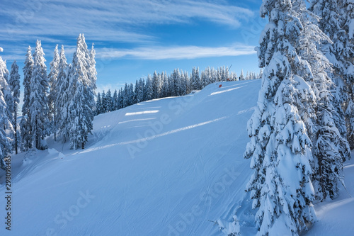 Skiers are getting ready to start skiing on white snowy steep slope. Calm beautiful early morning in ski resort.   Sports and recreation concept. Selective focus. © RaDa