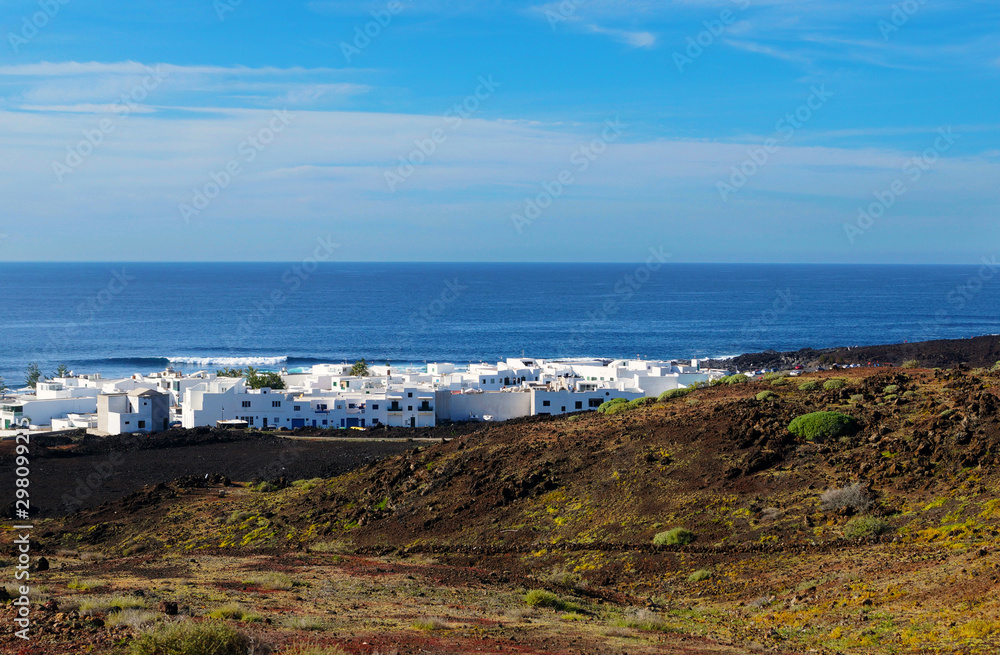 Amazing landscape of white houses placed on remote coast of calm blue sea under endless sky in Lanzarote, Canary islands, Spain Amazing landscape of white houses placed on remote coast of calm blue sea under endless sky in Lanzarote, Canary islands, Spain