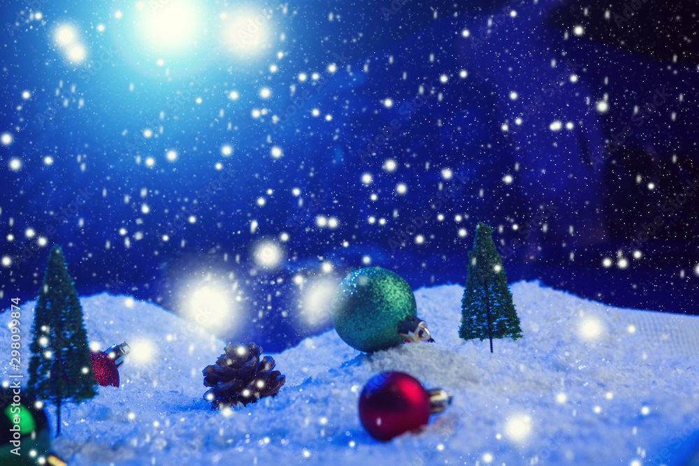 Christmas background with Christmas balls on snow over fir-tree, night sky and moon. Shallow depth of field. Christmas background. Fairy tale. Macro. Artificial magic dreamy world. Christmas background with Christmas balls on snow over fir-tree, night sky and moon. Shallow depth of field. Christmas background. Fairy tale. Macro. Artificial magic dreamy world.
