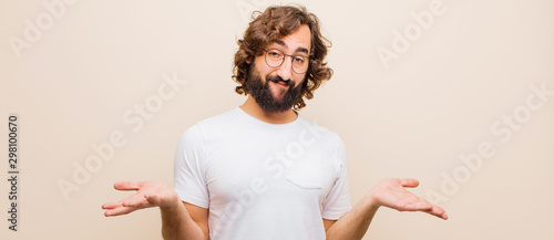Fotografía young bearded crazy man feeling puzzled and confused, unsure about the correct a