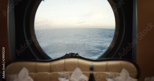 View through a porthole on a stormy sea with waves on cruise ship in restorante. photo