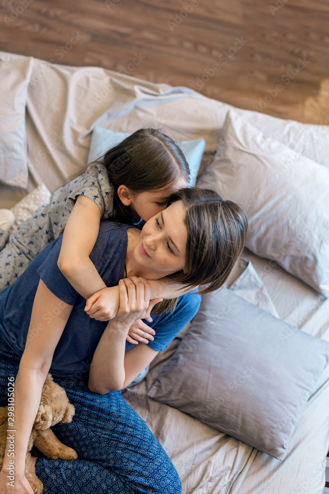 Loving young mother laughing hugging smiling cute funny baby daughter enjoying time together at home, happy family, little girl have fun playing feel joy and hugging Loving young mother laughing hugging smiling cute funny baby daughter enjoying time together at home, happy family, little girl have fun playing feel joy and hugging