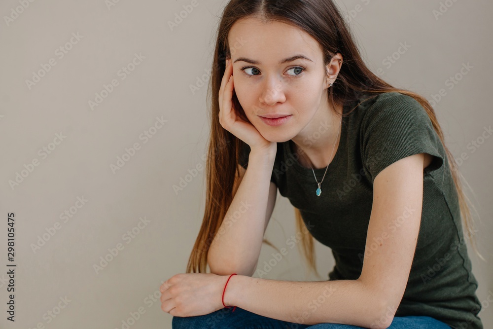 Portrait of real young woman in casual clothes without make up looking away Portrait of real young woman in casual clothes without make up looking away