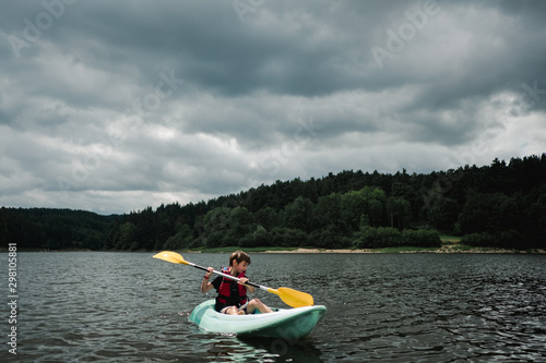 boy on a kayak on a lake on stormy day photo