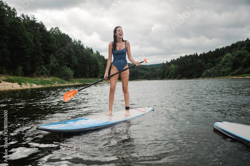 teen girl on paddle board on lake in France photo