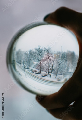 Crop hand holding sphere with winter landscape photo