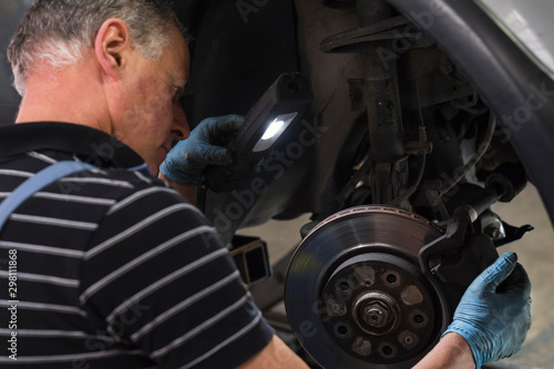 Mechanic checking car brakes photo