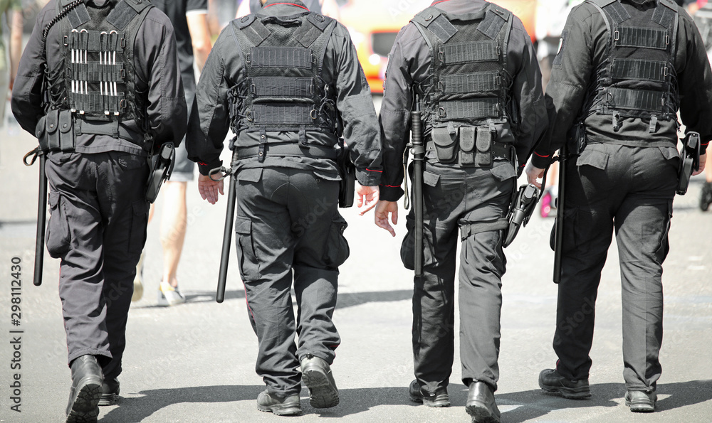 Four policemen with antiriot uniform Four policemen with antiriot uniform
