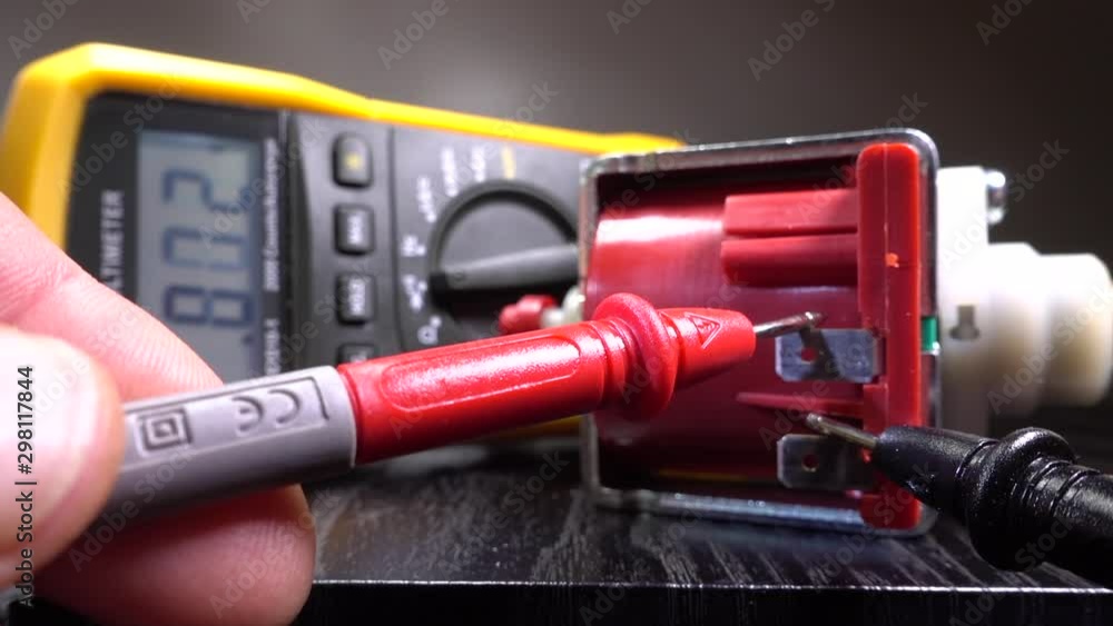 Slow motion close POV shot of a man’s hands attaching the probes of a digital multimeter to a small motor, to take a reading and check its functionality. Slow motion close POV shot of a man’s hands attaching the probes of a digital multimeter to a small motor, to take a reading and check its functionality.