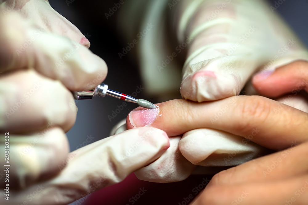Manicure. The device removes the cuticle. Moving aside cuticle from the surface of the nail Manicure. The device removes the cuticle. Moving aside cuticle from the surface of the nail