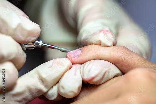 Manicure. The device removes the cuticle. Moving aside cuticle from the surface of the nail