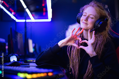 Cuadro en lienzo Streamer beautiful girl shows heart sign with hands professional gamer playing o