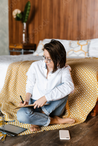 Casual girl with notepad in bedroom