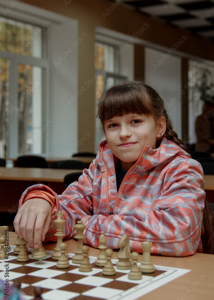 The girl plays chess. Figures on a chessboard. Game of chess. The girl plays chess. Figures on a chessboard. Game of chess.